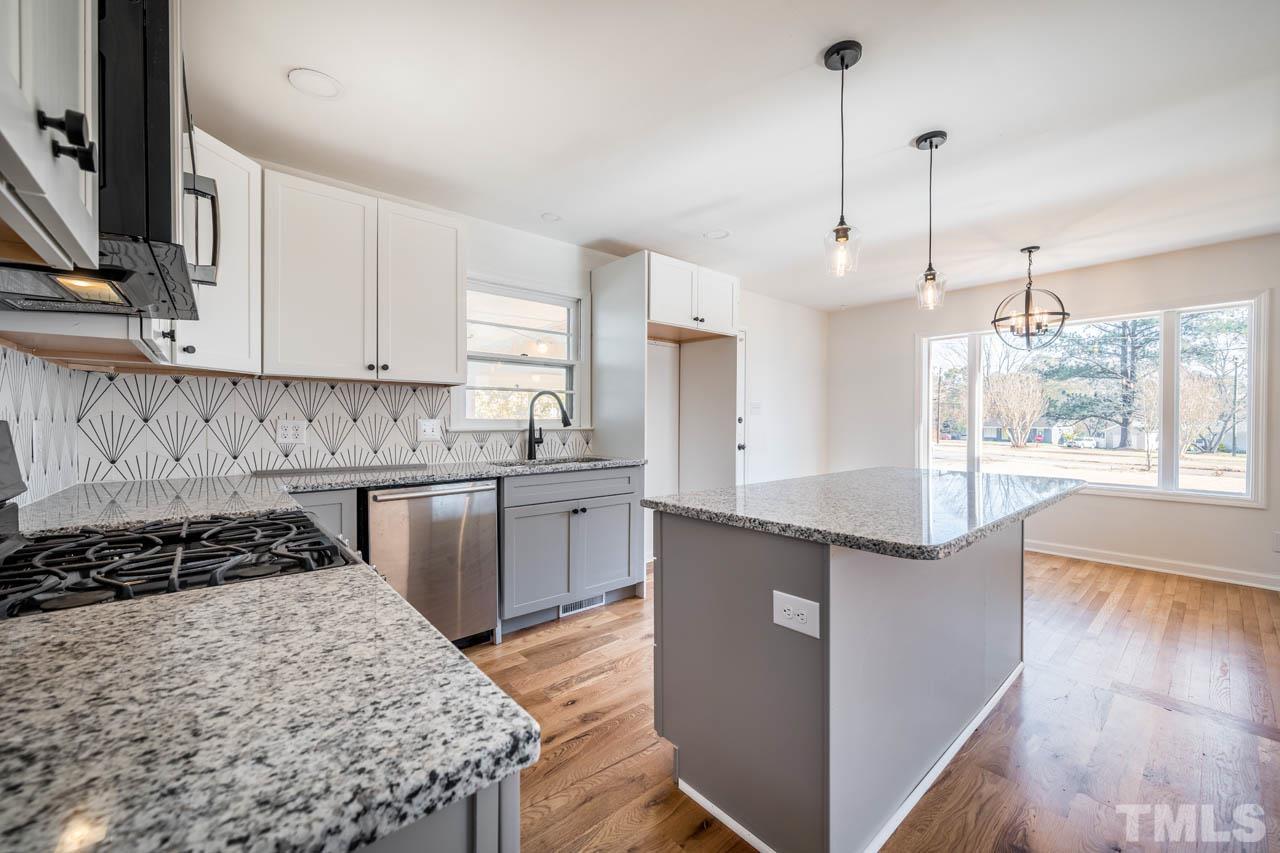 8 Holmes Circle Durham, NC 27713 - Photo 6 of 20 a kitchen with kitchen island granite countertop a sink stove and cabinets