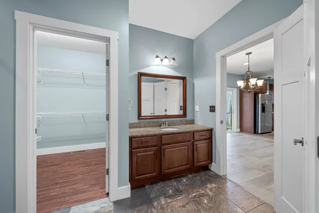 a spacious bathroom with a granite countertop sink a mirror and shower