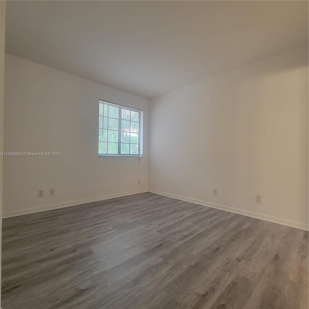 3883 Tree Top Drive Weston, FL 33332 - Photo 17 of 22 an empty room with wooden floor and window