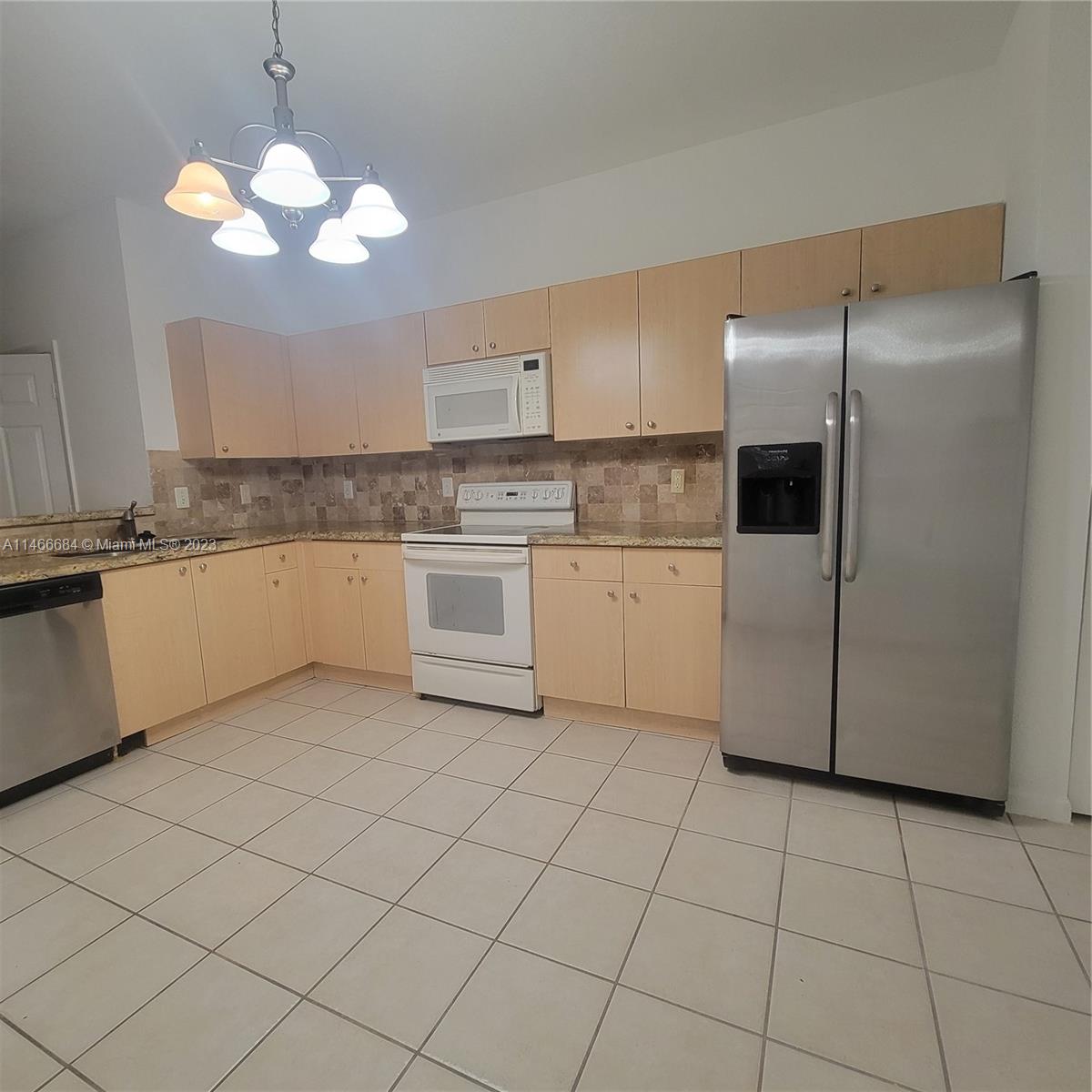 3883 Tree Top Drive Weston, FL 33332 - Photo 2 of 22 a kitchen with stainless steel appliances granite countertop a sink a stove a refrigerator and white cabinets