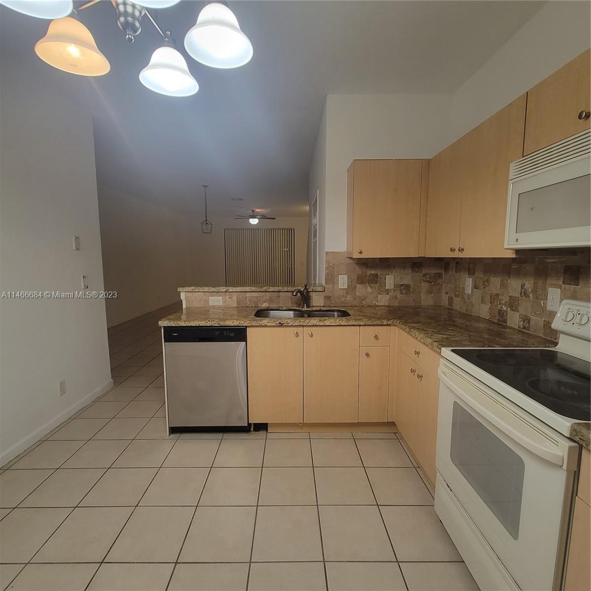 3883 Tree Top Drive Weston, FL 33332 - Photo 3 of 22 a kitchen with a sink cabinets and appliances