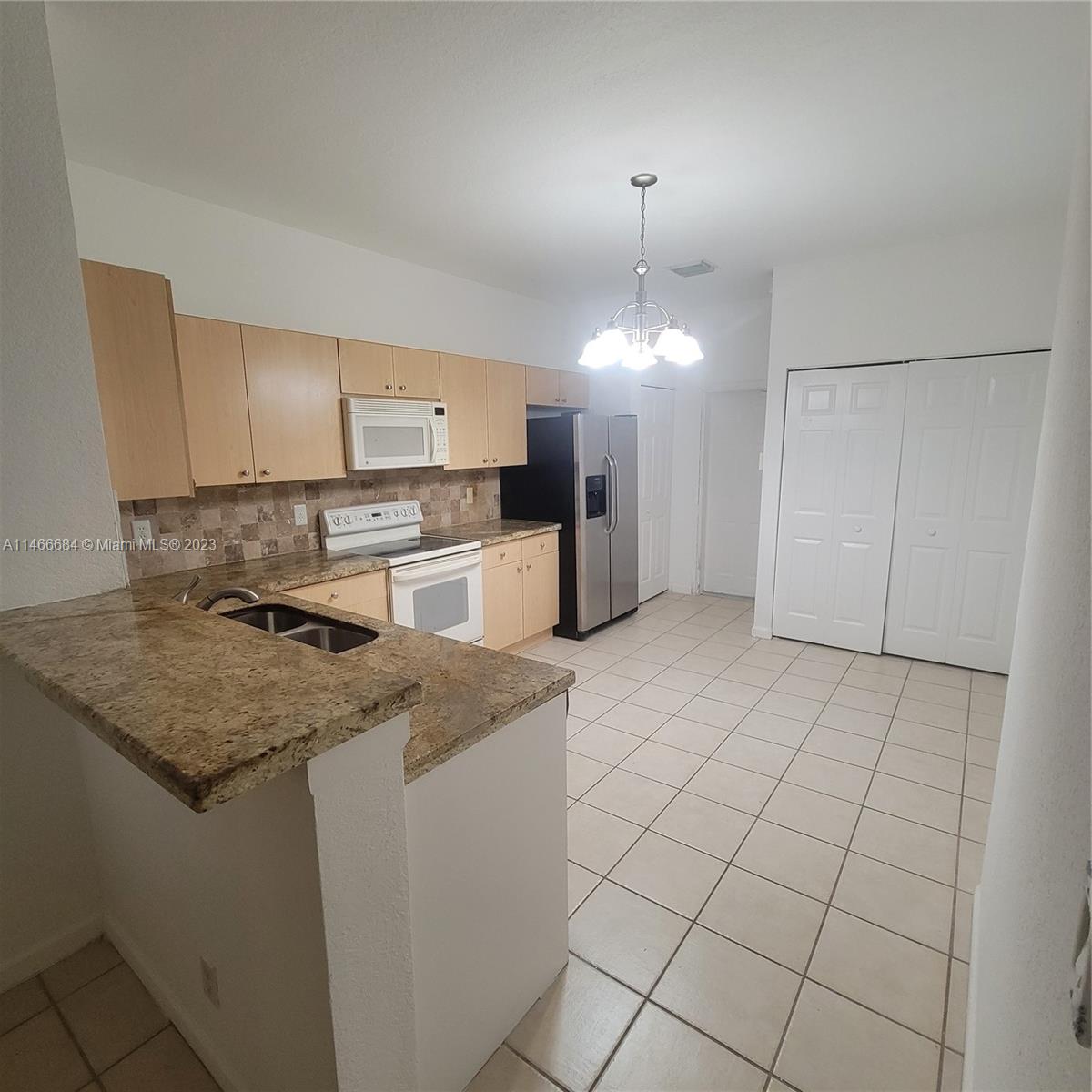 3883 Tree Top Drive Weston, FL 33332 - Photo 4 of 22 a kitchen with a stove a sink and a refrigerator