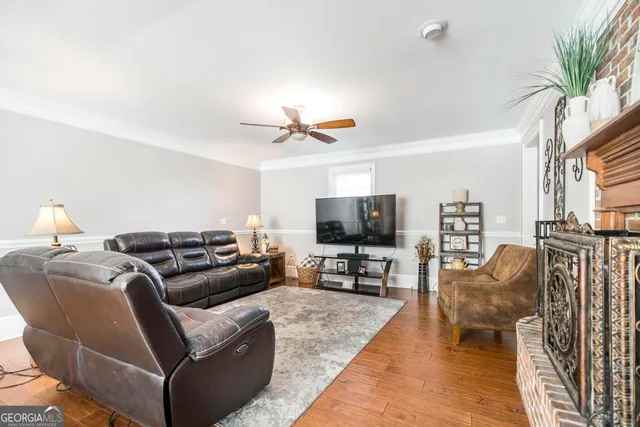 a living room with furniture and a flat screen tv with wooden floor