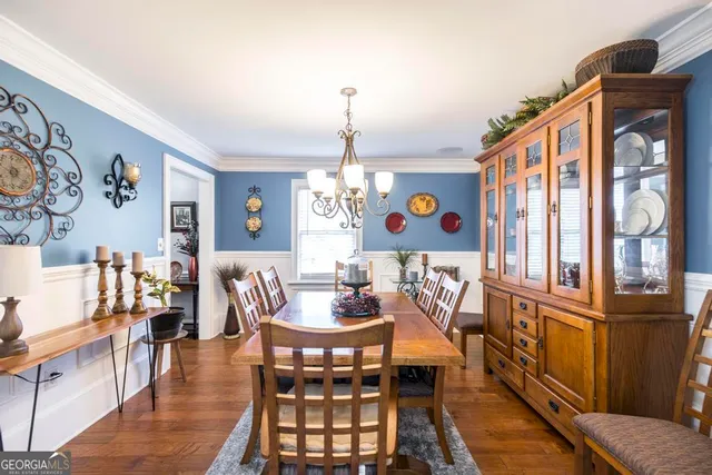a dining room with furniture a chandelier and wooden floor