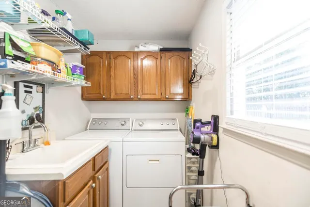 a utility room with a sink dryer and washer