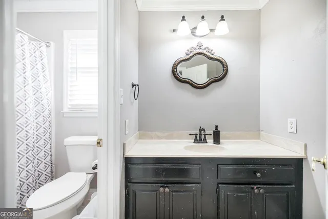 a bathroom with a sink a toilet and a mirror