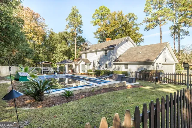 a view of a house with backyard and sitting area