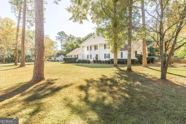 a view of a house with a yard and tree s