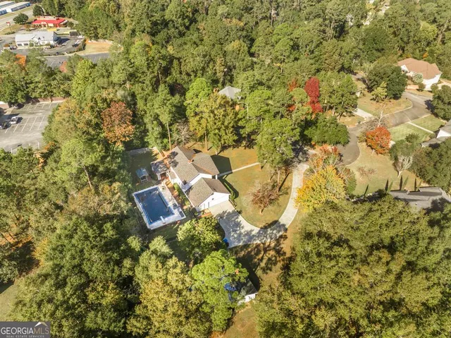 an aerial view of residential house with swimming pool and green space