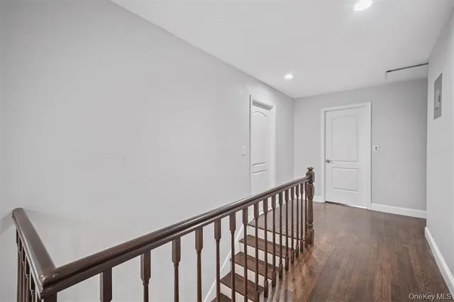 a large white kitchen with wooden floors and stainless steel appliances