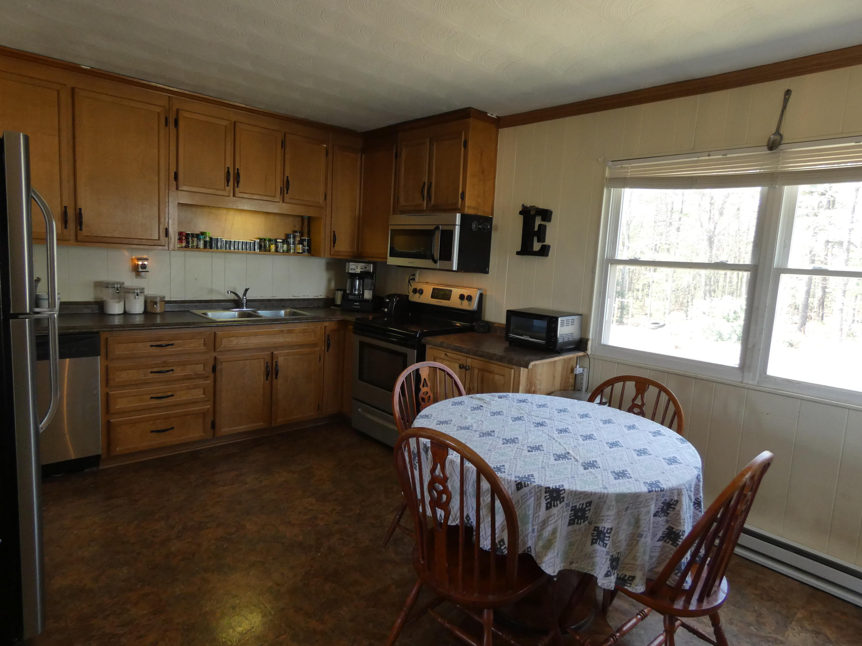 6779 Conner Road Northeast Copper Hill, VA 24079 - Photo 4 of 18 a kitchen with granite countertop a stove a sink a dining table and chairs