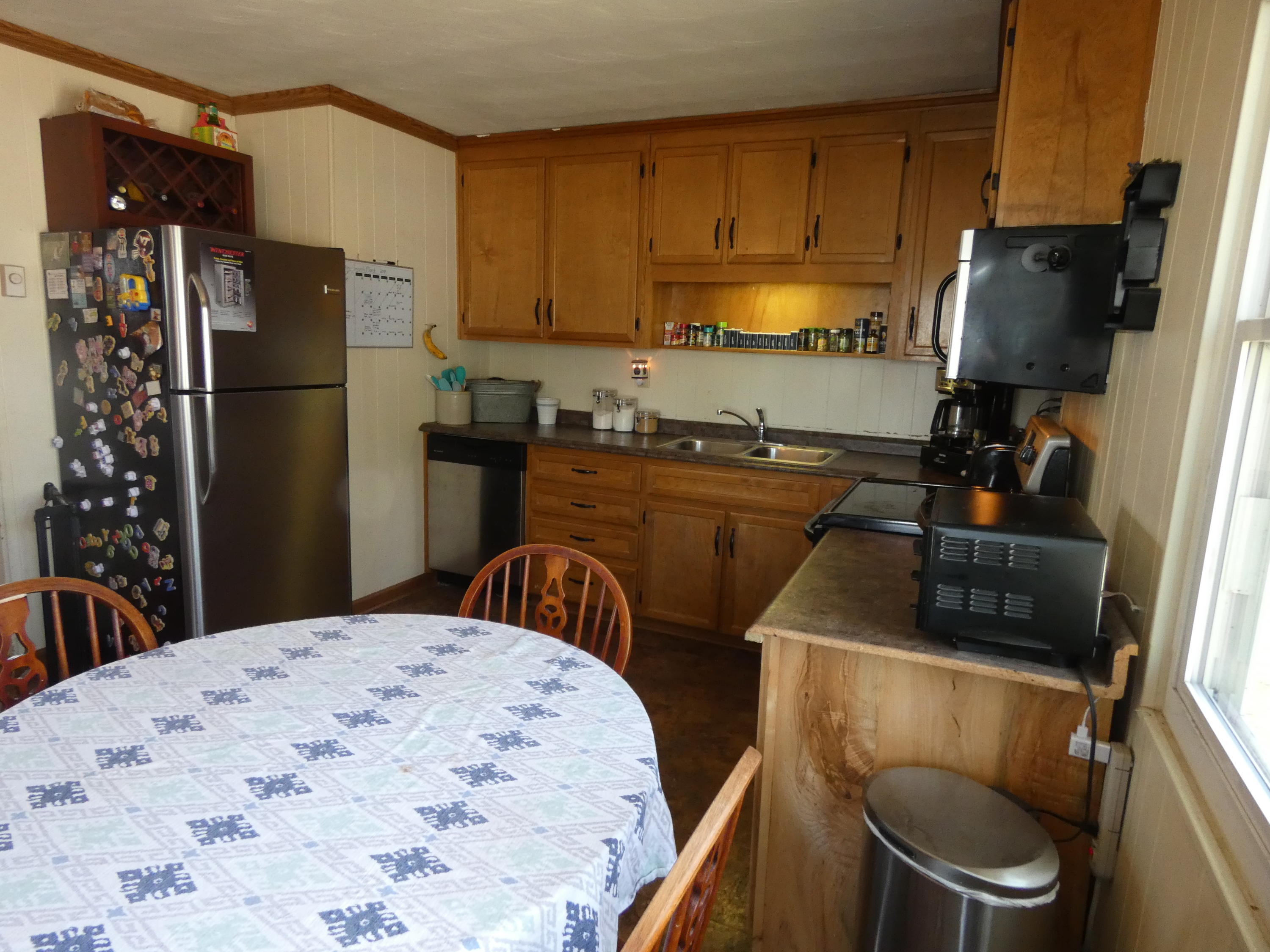 6779 Conner Road Northeast Copper Hill, VA 24079 - Photo 5 of 18 a kitchen with a refrigerator a stove a sink dishwasher and wooden cabinets