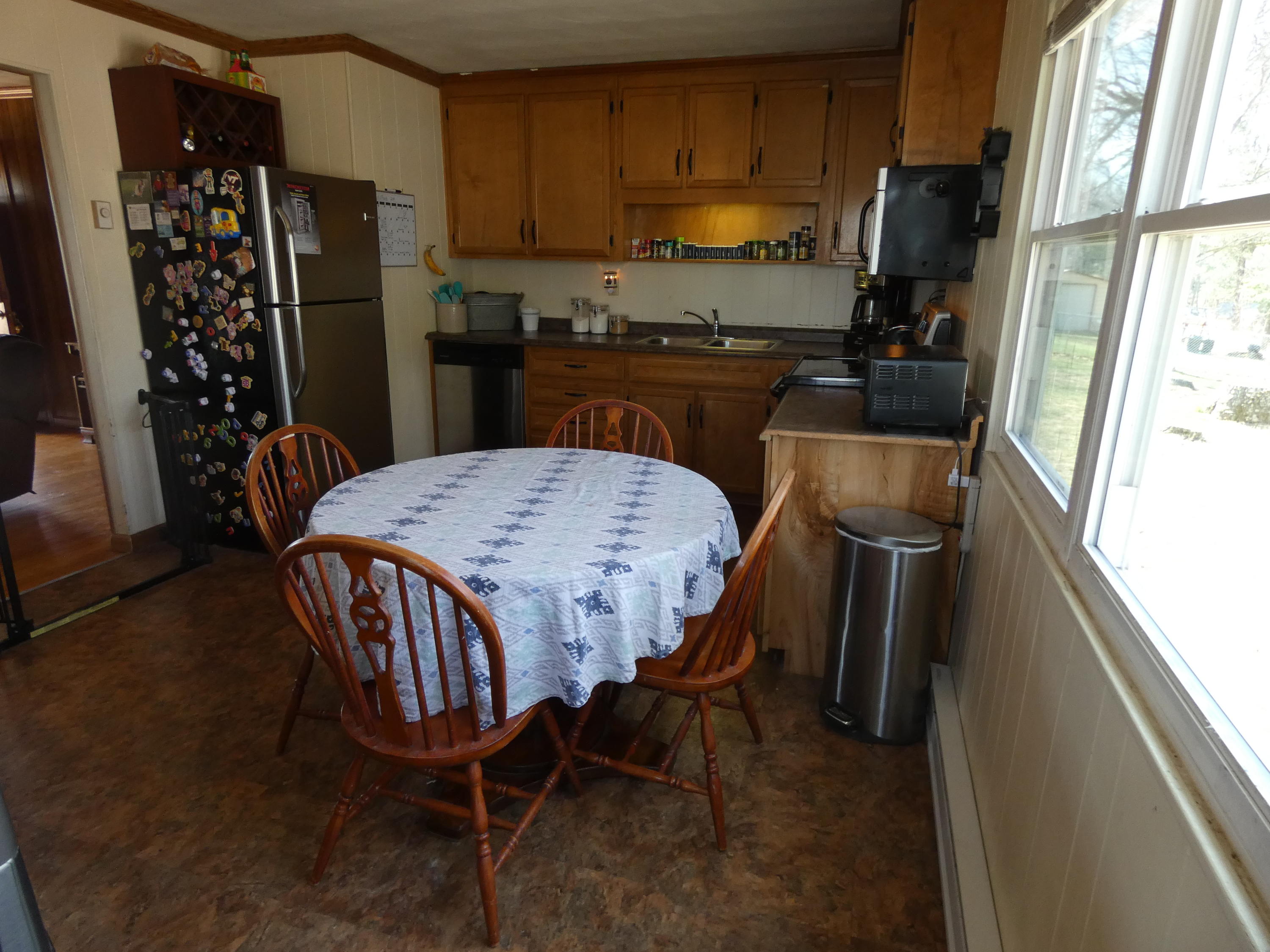 6779 Conner Road Northeast Copper Hill, VA 24079 - Photo 6 of 18 a kitchen with stainless steel appliances a refrigerator a sink a stove a table and chairs