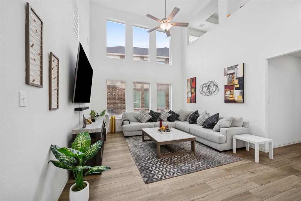 a living room with furniture chandelier and a flat screen tv
