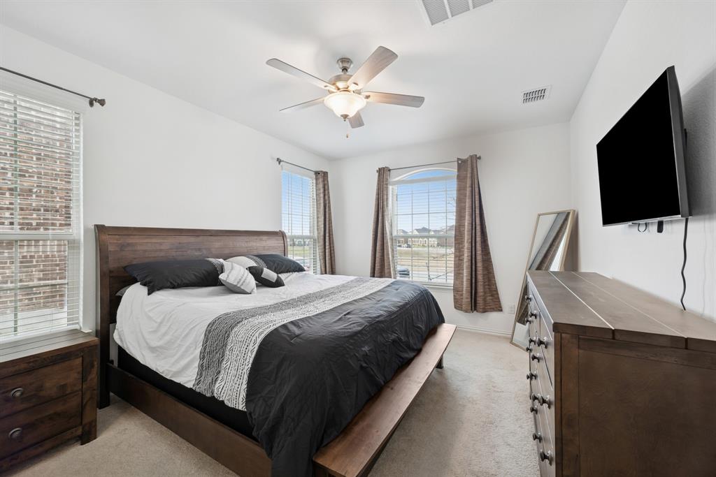 10040 Thornapple Road Fort Worth, TX 76179 - Photo 24 of 24 a bedroom with a bed window and a flat screen tv
