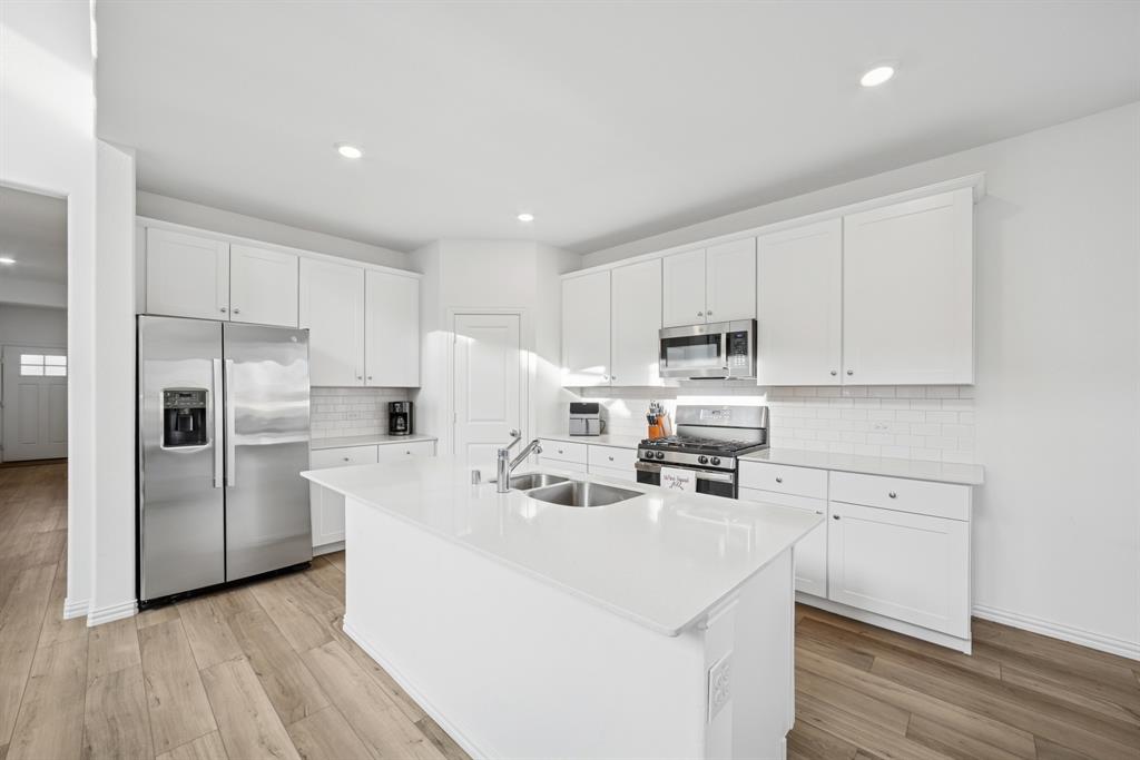 10040 Thornapple Road Fort Worth, TX 76179 - Photo 2 of 24 a kitchen with stainless steel appliances a refrigerator sink and microwave