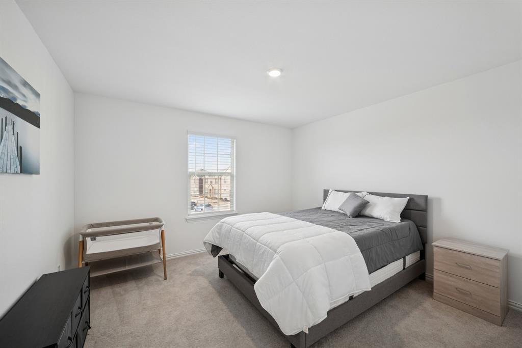 10040 Thornapple Road Fort Worth, TX 76179 - Photo 19 of 24 a bedroom with a bed and a window