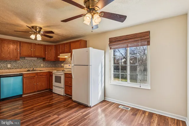 a kitchen with refrigerator cabinets and wooden floor