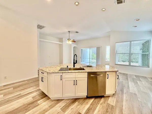 a view of cabinets counter top with stainless steel appliances granite countertop cabinets and wooden floor