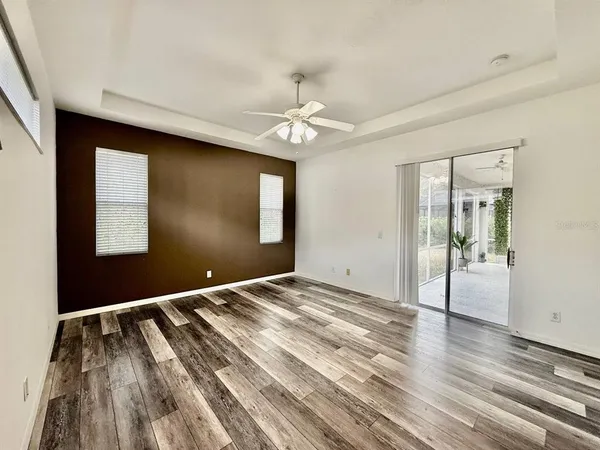 a view of an empty room with window and wooden floor