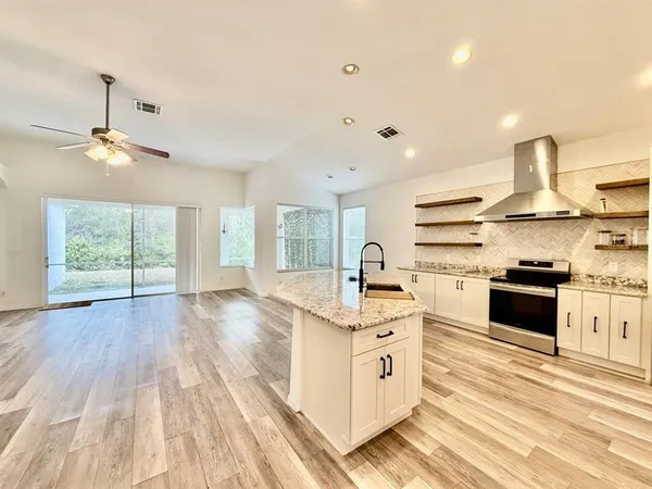a kitchen with stainless steel appliances a stove sink and cabinets