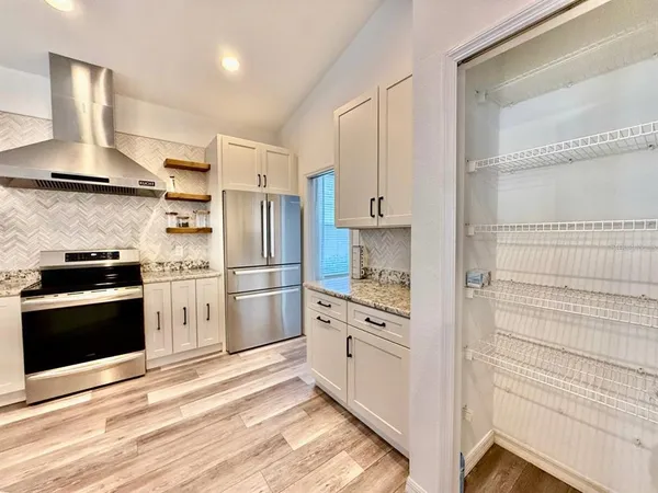 a kitchen with white cabinets and stainless steel appliances