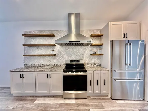 a kitchen with stainless steel appliances granite countertop a stove and a refrigerator