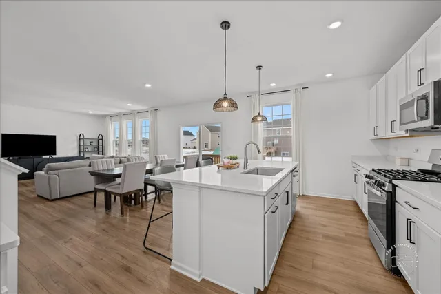 a kitchen with kitchen island granite countertop a sink a counter top space and stainless steel appliances