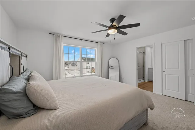 a bedroom with a large bed and ceiling fan