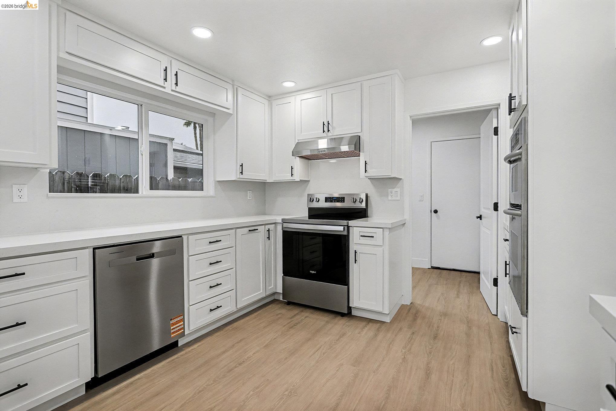 4741 Discovery Point Discovery Bay, CA 94505 - Photo 17 of 52 a kitchen with stainless steel appliances white cabinets and wooden floors