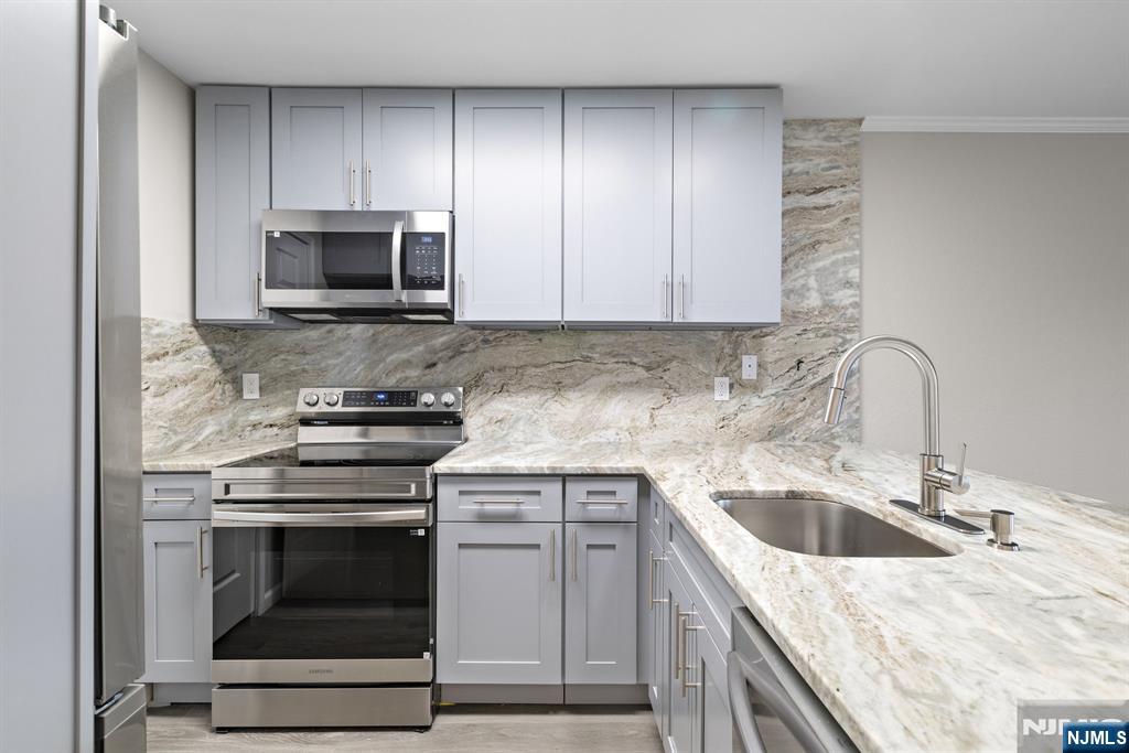 690 Rt 23, Unit R3 Wayne, NJ 07470 - Photo 3 of 11 a kitchen with white cabinets appliances and sink