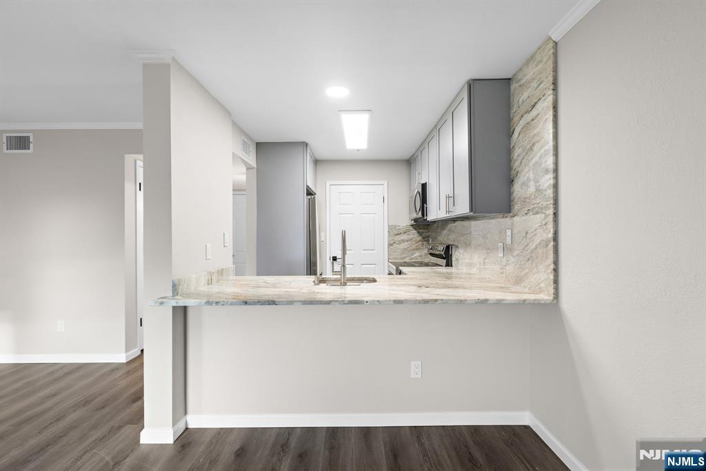 690 Rt 23, Unit R3 Wayne, NJ 07470 - Photo 5 of 11 a view of a kitchen with kitchen island a sink wooden floor and black appliances
