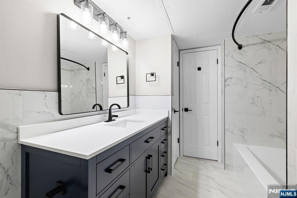 690 Rt 23, Unit R3 Wayne, NJ 07470 - Photo 8 of 11 a bathroom with a sink and a mirror