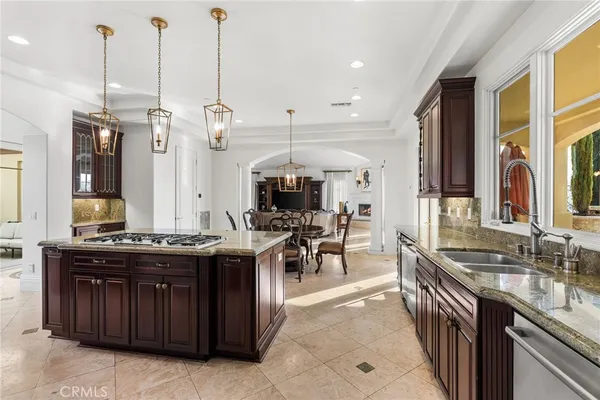 a kitchen with stainless steel appliances granite countertop a stove a sink and a wooden floors