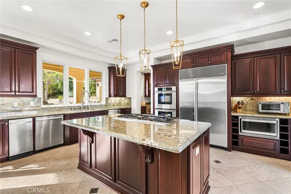 a kitchen with stainless steel appliances granite countertop a sink a stove and a refrigerator