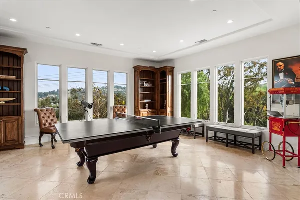 a living room with furniture pool table and a large window