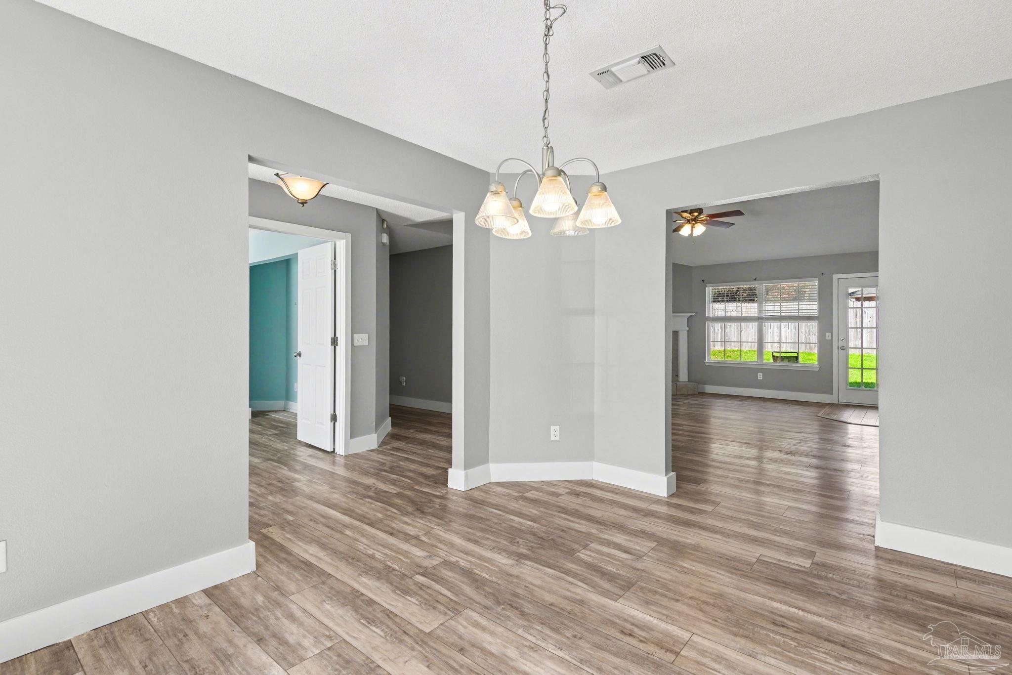 1648 Condor Drive Cantonment, FL 32533 - Photo 16 of 51 a view of a hallway with wooden floor and chandelier