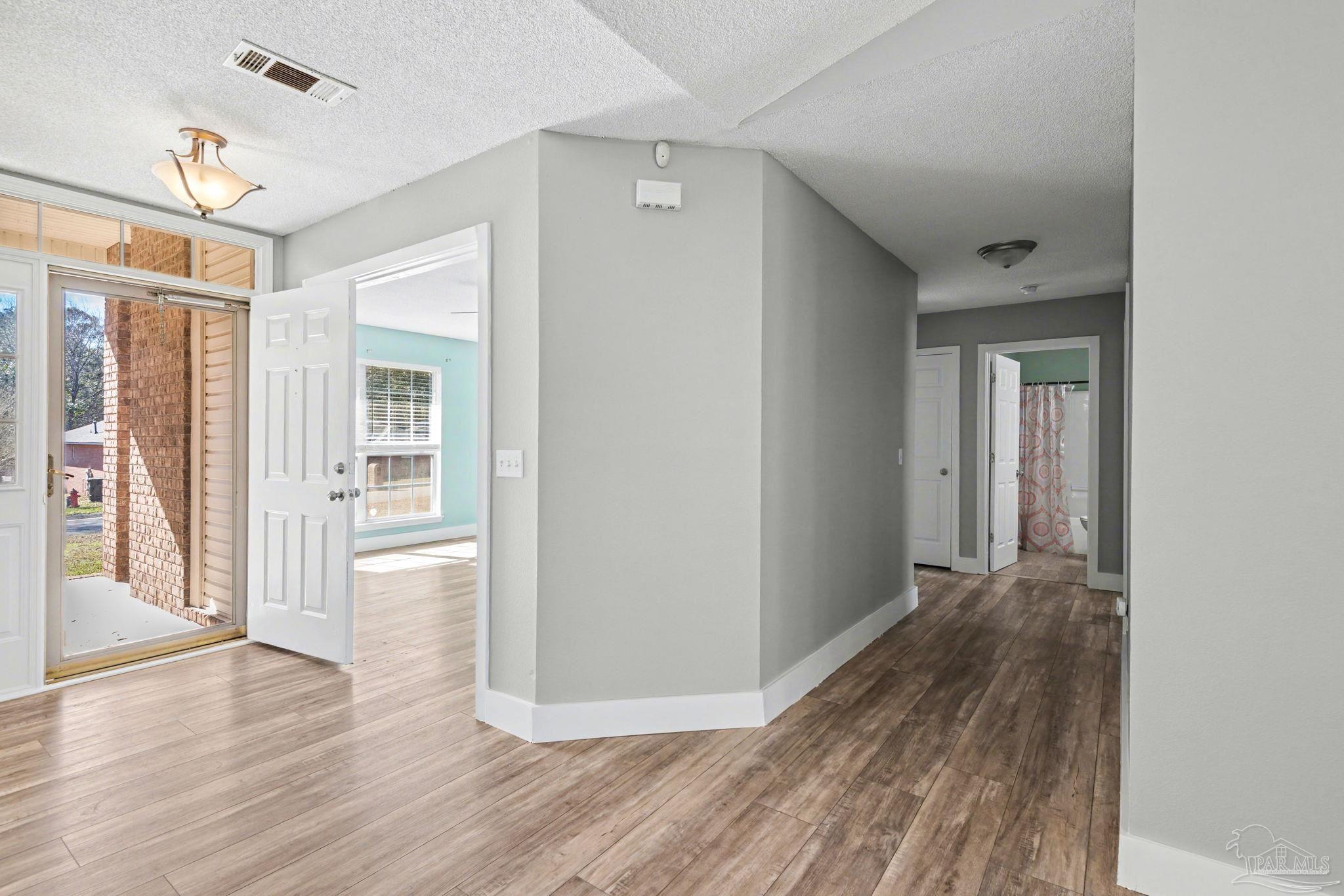 1648 Condor Drive Cantonment, FL 32533 - Photo 35 of 51 a view of a hallway with wooden floor and a bathroom