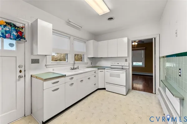 a kitchen with granite countertop a stove top oven sink and cabinets