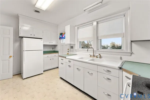 a kitchen with cabinets appliances a sink and a window