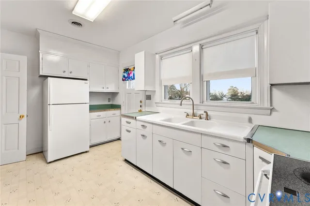a kitchen with cabinets appliances a sink and a window