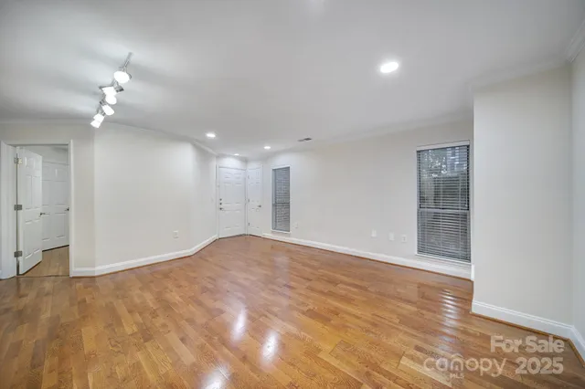 a view of a big room with wooden floor and a kitchen