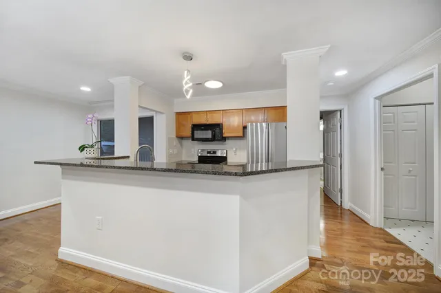 a view of a kitchen with a sink and dishwasher a stove top oven with wooden floor