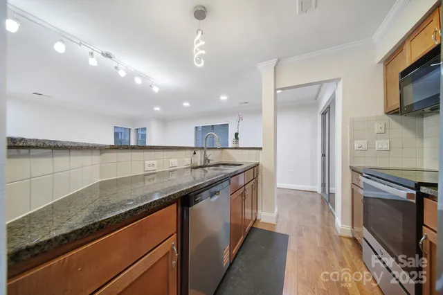 a kitchen with stainless steel appliances granite countertop a sink and a stove