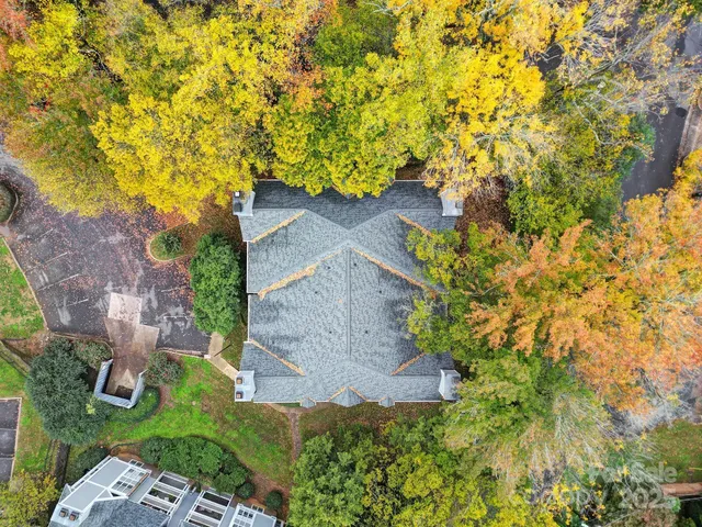 a view of an empty room with kitchen and window