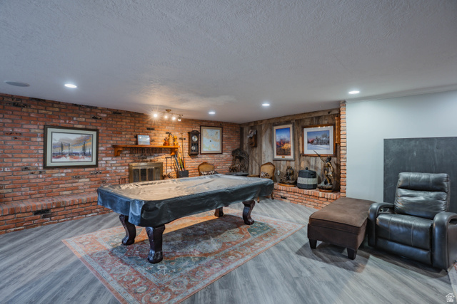 980 Cactus Circle St. George, UT 84790 - Photo 29 of 77 Game room with a brick fireplace, wood finished floors, brick wall, billiards table, and recessed lighting