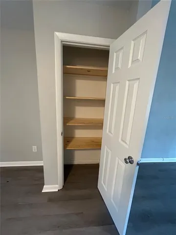a view of walk in closet with empty racks