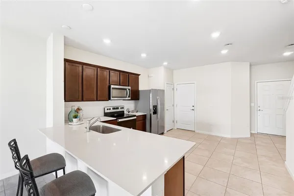 a kitchen with a refrigerator a stove top oven cabinets a sink and a counter top
