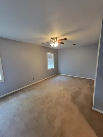 a view of an empty room with a ceiling fan