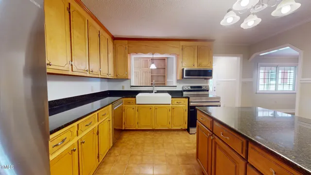a kitchen with stainless steel appliances granite countertop a stove a sink and a microwave